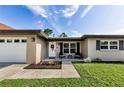 Inviting front porch with seating, a white front door, and a view of the landscaped front yard at 1800 Mapleleaf Blvd, Oldsmar, FL 34677