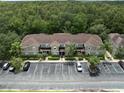 Aerial view of townhouses with parking, surrounded by lush greenery and a beautiful wooded area at 2349 Willimette Dr, Wesley Chapel, FL 33543