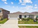 Inviting single-story home with two-car garage, stone veneer accents, and well-manicured lawn under a partly cloudy sky at 2518 Chapel Oak Bnd, Wesley Chapel, FL 33543