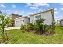 Single-story home with a two-car garage, stone accents, and lush landscaping adding curb appeal at 2518 Chapel Oak Bnd, Wesley Chapel, FL 33543