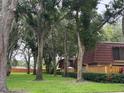 Landscaped lawn and mature trees enhance the charming townhome with red tile roof at 2716 11Th Ct, Palm Harbor, FL 34684
