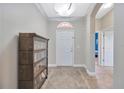 Inviting foyer features neutral paint, tiled flooring, and decorative light fixture at 31241 Kirkshire Ct, Wesley Chapel, FL 33543