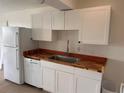 Bright kitchen features white cabinets, wood countertops, stainless steel sink and appliances at 320 N Bayshore Blvd # 203, Clearwater, FL 33759