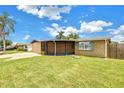 Attractive single-story home with a screened patio and manicured lawn at 3743 Cherrywood Dr, Holiday, FL 34691