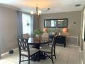 Bright dining room with a round table set, chandelier, and neutral color palette at 3811 Elmwood Dr, Holiday, FL 34691