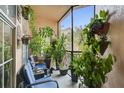 Relaxing balcony with blue seating area and a variety of lush plants at 4221 W Spruce St # 2328, Tampa, FL 33607