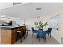 Open dining area adjacent to the kitchen and breakfast bar, with contemporary lighting and decor at 450 Treasure Isle Causeway # 212, Treasure Island, FL 33706