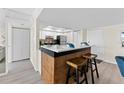 Modern kitchen features a beautiful breakfast bar with granite countertops and wood accents with white appliances and cabinets at 450 Treasure Isle Causeway # 212, Treasure Island, FL 33706