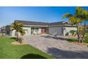 Well-maintained home boasts a brick driveway, two-car garage, and lush landscaping for an inviting exterior at 5133 Glenn Dr, New Port Richey, FL 34652
