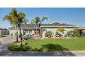 Beautifully landscaped front yard with green grass, plants, and brick driveway leading to the cozy home at 5133 Glenn Dr, New Port Richey, FL 34652