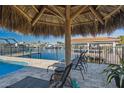 Relaxing poolside view with lounge chairs, a tiki umbrella, and waterfront views at 5133 Glenn Dr, New Port Richey, FL 34652