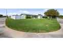 Corner lot showcasing a spacious green lawn and white fence, offering privacy and a park-like setting at 5720 Mockingbird Dr, New Port Richey, FL 34652