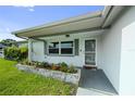 Inviting front entrance with gray trim, decorative planter boxes, and a screen door for fresh air at 5720 Mockingbird Dr, New Port Richey, FL 34652