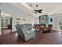Comfortable living room with plush seating, fireplace, ceiling fan, and large windows for natural light at 101 Carlyle Dr, Palm Harbor, FL 34683
