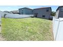 Spacious backyard with a well-maintained lawn and a white fence, perfect for outdoor activities and privacy at 10221 Carloway Hills Dr, Wimauma, FL 33598