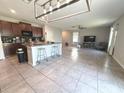 Open kitchen featuring a large island, modern appliances, and seamless integration with the living area at 10221 Carloway Hills Dr, Wimauma, FL 33598