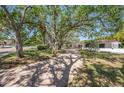 Inviting single-story home with a brick paved driveway and lush lawn leading to the entrance at 1100 Snell Isle Ne Blvd, St Petersburg, FL 33704