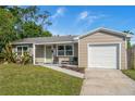 Charming single-story home with a well-maintained lawn, neutral colors, and attached one car garage at 124 E Virginia Ln, Clearwater, FL 33759