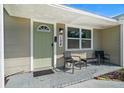 Inviting front porch with a green door, black seating, and stylish address numbers at 124 E Virginia Ln, Clearwater, FL 33759