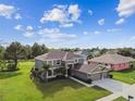 Aerial view of a two-story home with lush green lawn, mature trees and two car garage at 12915 Carlington Ln, Riverview, FL 33579