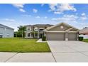 Home exterior showcasing lush landscaping, a well-kept lawn, and an attached two-car garage at 12915 Carlington Ln, Riverview, FL 33579