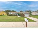 Attractive single-story home with well-manicured lawn and a quaint mailbox along the sidewalk at 13311 Omega Ct, Dade City, FL 33525
