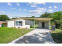 Charming single-story home with a covered carport, neat landscaping, and freshly cut green grass at 2017 Waikiki Way, Tampa, FL 33619