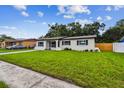 A neat single-level home with a lush green lawn and a clean, modern aesthetic at 2027 Balfour Cir, Tampa, FL 33619