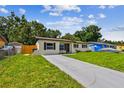 A quaint single-Gathering home featuring a freshly mowed lawn and a concrete driveway at 2027 Balfour Cir, Tampa, FL 33619