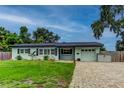 Charming single-story home with a well-manicured lawn, brick driveway, and light blue exterior at 2192 Robinson Dr, St Petersburg, FL 33710