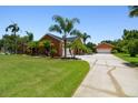 Exterior side view of a home with lush landscaping, driveway, and a detached two-car garage at 2513 Martucci Rd, Seffner, FL 33584