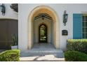 Arched entrance featuring stone details, custom lighting, and well-maintained landscaping at 4525 W Swann Ave, Tampa, FL 33609