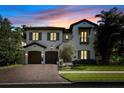 Exterior view of a charming two-story home with a paver driveway at dusk at 4525 W Swann Ave, Tampa, FL 33609
