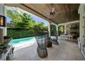 Inviting covered patio with wicker chairs, dining area, outdoor grill and a beautiful view of the private pool at 4525 W Swann Ave, Tampa, FL 33609