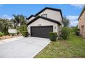 Exterior view of two-story home highlighting the garage and partial landscaped yard at 4738 Bloom Dr, Plant City, FL 33566