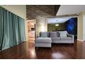 Inviting living room featuring hardwood floors, stylish furnishings, and a unique accent wall at 4811 Puritan Cir # 4811, Tampa, FL 33617