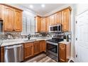 Modern kitchen features stainless steel appliances, granite countertops, and wooden cabinets for a functional and stylish cooking space at 539 Treviso Dr, Apollo Beach, FL 33572