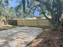 Large backyard with a newly installed wooden fence, and a concrete driveway providing ample parking at 6427 2Nd S Ave, St Petersburg, FL 33707