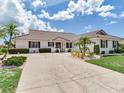 Charming home with a tile roof, palm trees, and large driveway at 702 Plumbrook Rd, Sun City Center, FL 33573