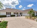 Charming home with a tile roof, palm trees, and large driveway at 702 Plumbrook Rd, Sun City Center, FL 33573