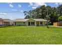 Inviting single-story home boasts a well-manicured lawn and quaint, covered front porch at 7308 Avonwood St, Tampa, FL 33625