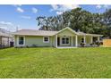 Single-story home with large lawn and covered front porch, perfect for enjoying the outdoors at 7308 Avonwood St, Tampa, FL 33625