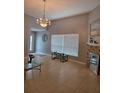 Bright living room featuring tile floors, large window, and elegant chandelier at 8718 Lindenhurst Pl, Tampa, FL 33634