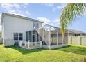 Exterior view of the backyard with an enclosed screened patio, wooden deck and green grass at 915 Windton Oak Dr, Ruskin, FL 33570