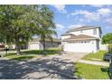 Two-story home has a well-manicured lawn and an attached two car garage at 915 Windton Oak Dr, Ruskin, FL 33570