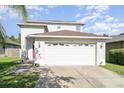 A large two car garage is attached to the two-story home, with a well-manicured lawn at 915 Windton Oak Dr, Ruskin, FL 33570