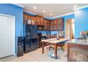 Cozy kitchen with dark wood cabinetry, black appliances, and a dining table with tiled floor at 915 Windton Oak Dr, Ruskin, FL 33570