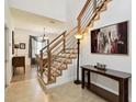 Bright foyer featuring wood stairs with modern metal railings and neutral tile floors that offers view to the dining area at 1032 Jacob Way, Odessa, FL 33556