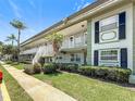 Inviting exterior of the condo building with white trim, balconies, and lush green landscaping at 1433 S Belcher Rd # B11, Clearwater, FL 33764