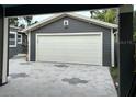 Detached two-car garage with white door and modern gray siding at 1601 14Th N St, St Petersburg, FL 33704